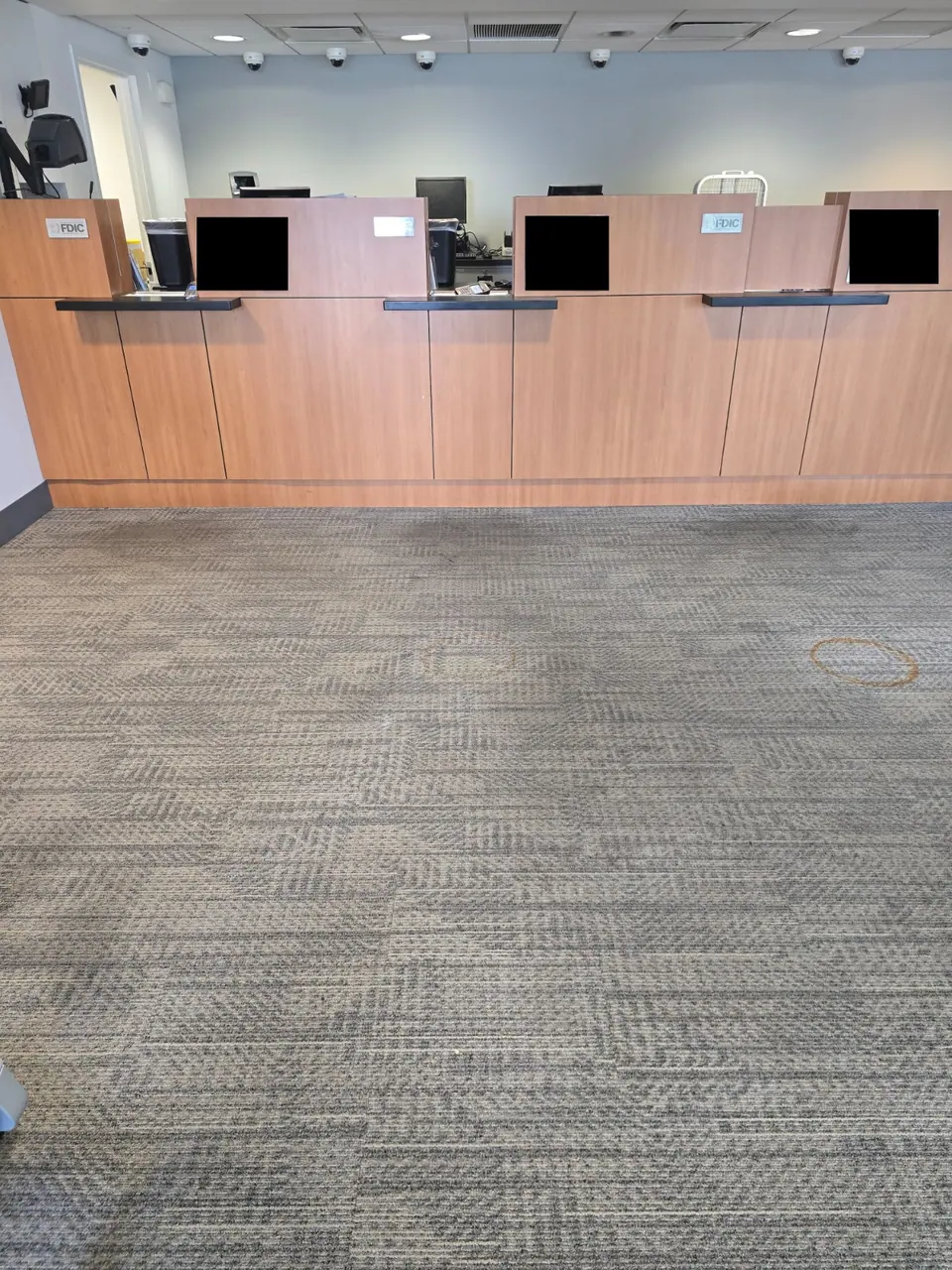 Carpet at a commercial counter before cleaning, with a visible ring mark.