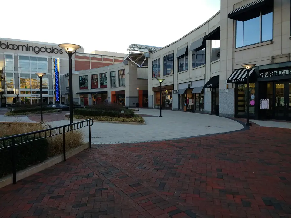 Shopfronts and a brick-paved pedestrian plaza at Wisconsin Place in Chevy Chase, Maryland.