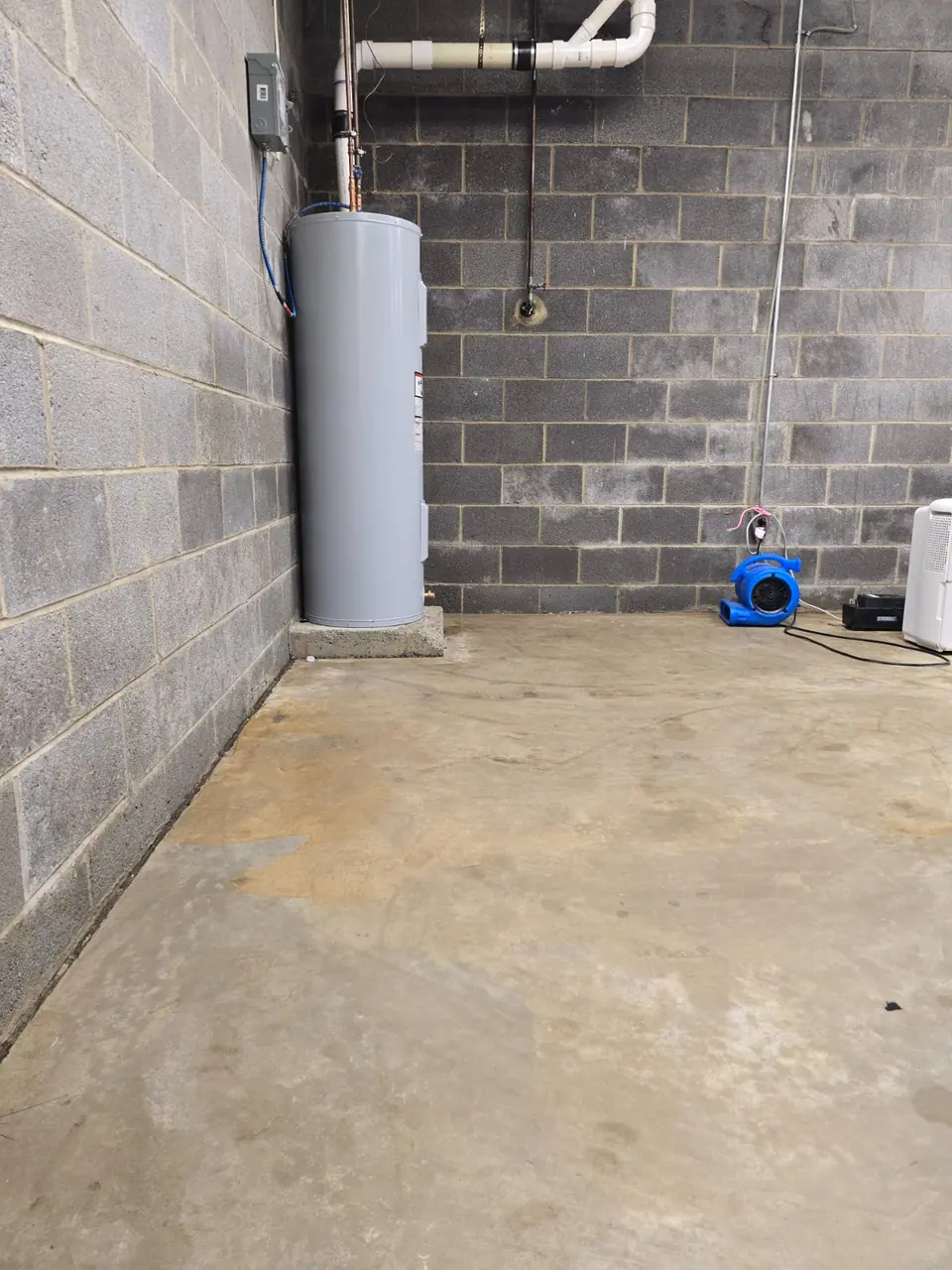 Utility-room floor after cleaning, with drying equipment visible.