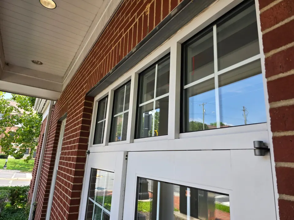 Clean exterior window panels along a brick commercial building.